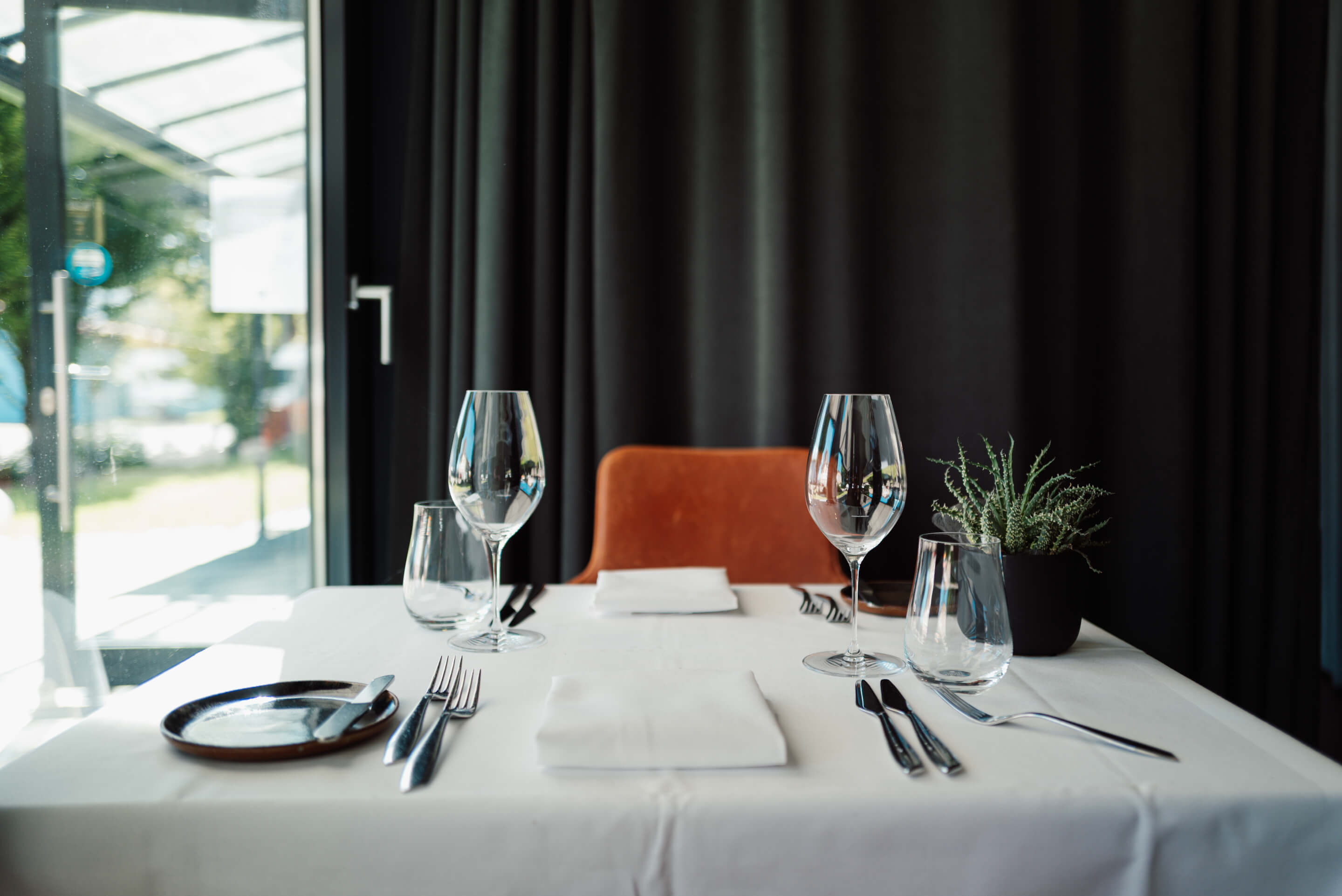 Ein Tisch für zwei Personen (Open-Table) mit weißer Tischdecke, edlem Besteck und schönen Gläsern