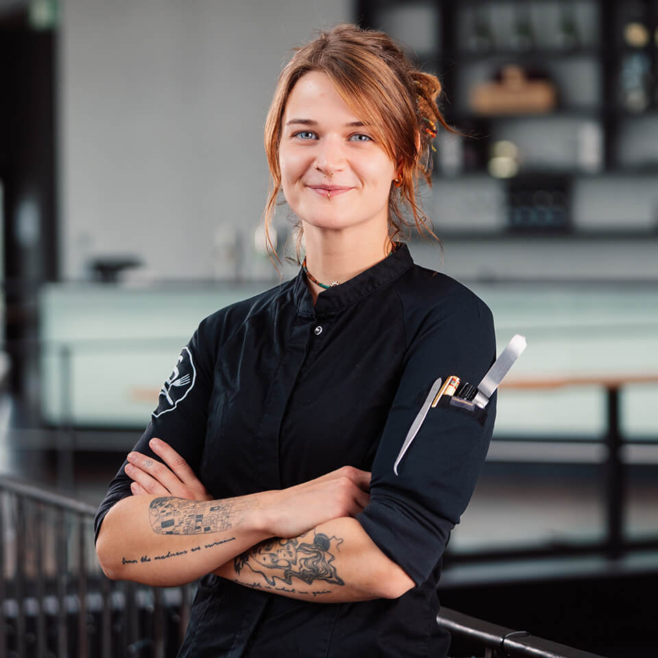 Chef Pattisière Lillia Bremer mit den Armen vor dem Körper verschränkt.