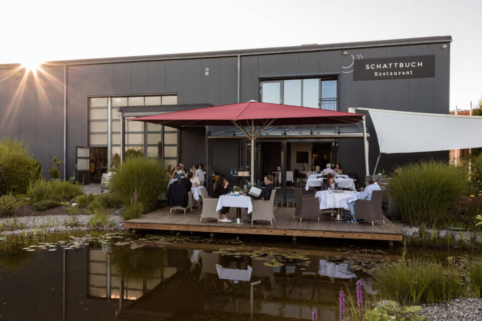 Sonnenterrasse zur Goldenen Stunde bei Sonnenuntergang, Gäste nehmen Platz