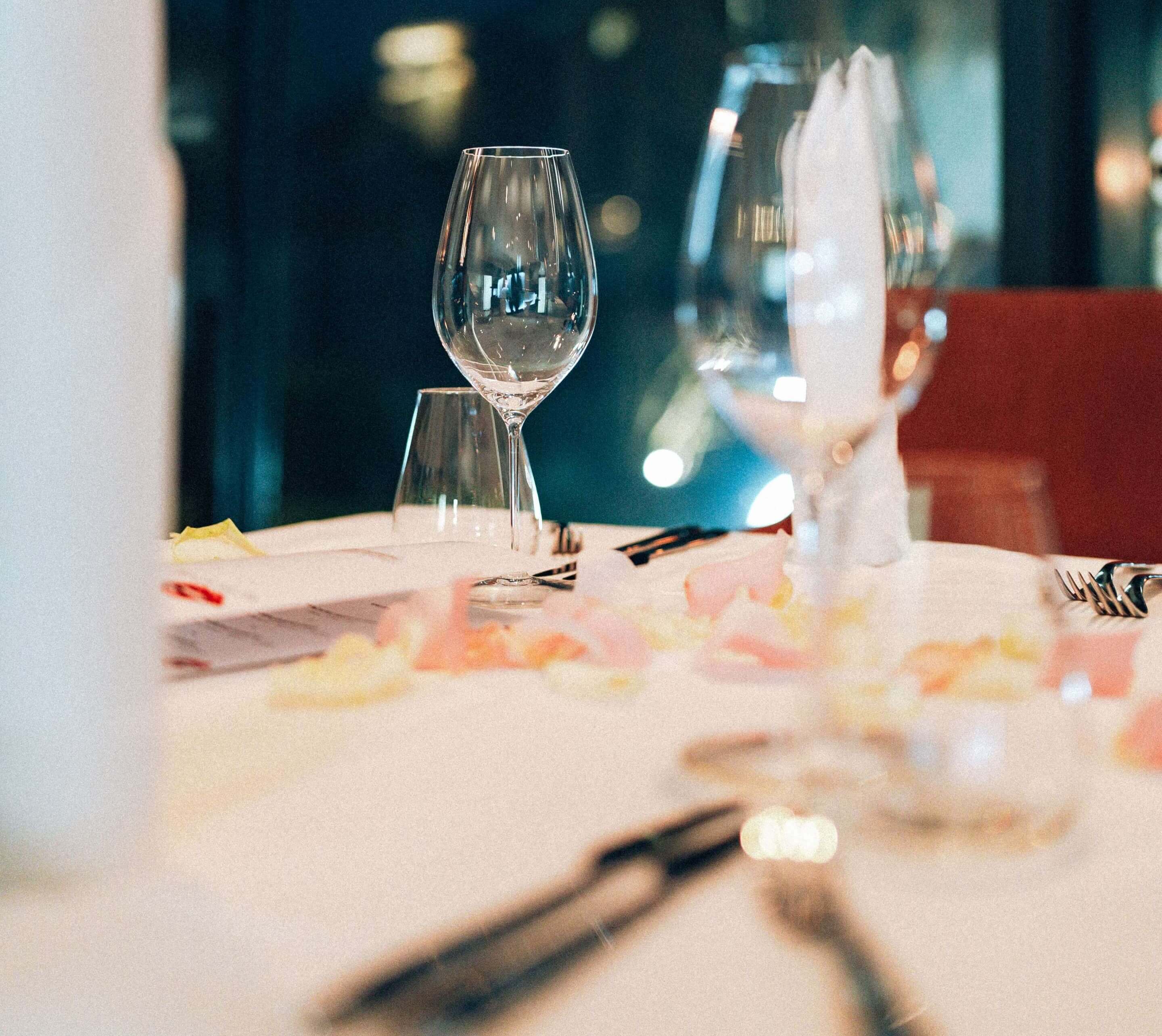 Detailaufnahme des Gedecks mit Rosenblättern bei Abendstimmung im Restaurant Schattbuch