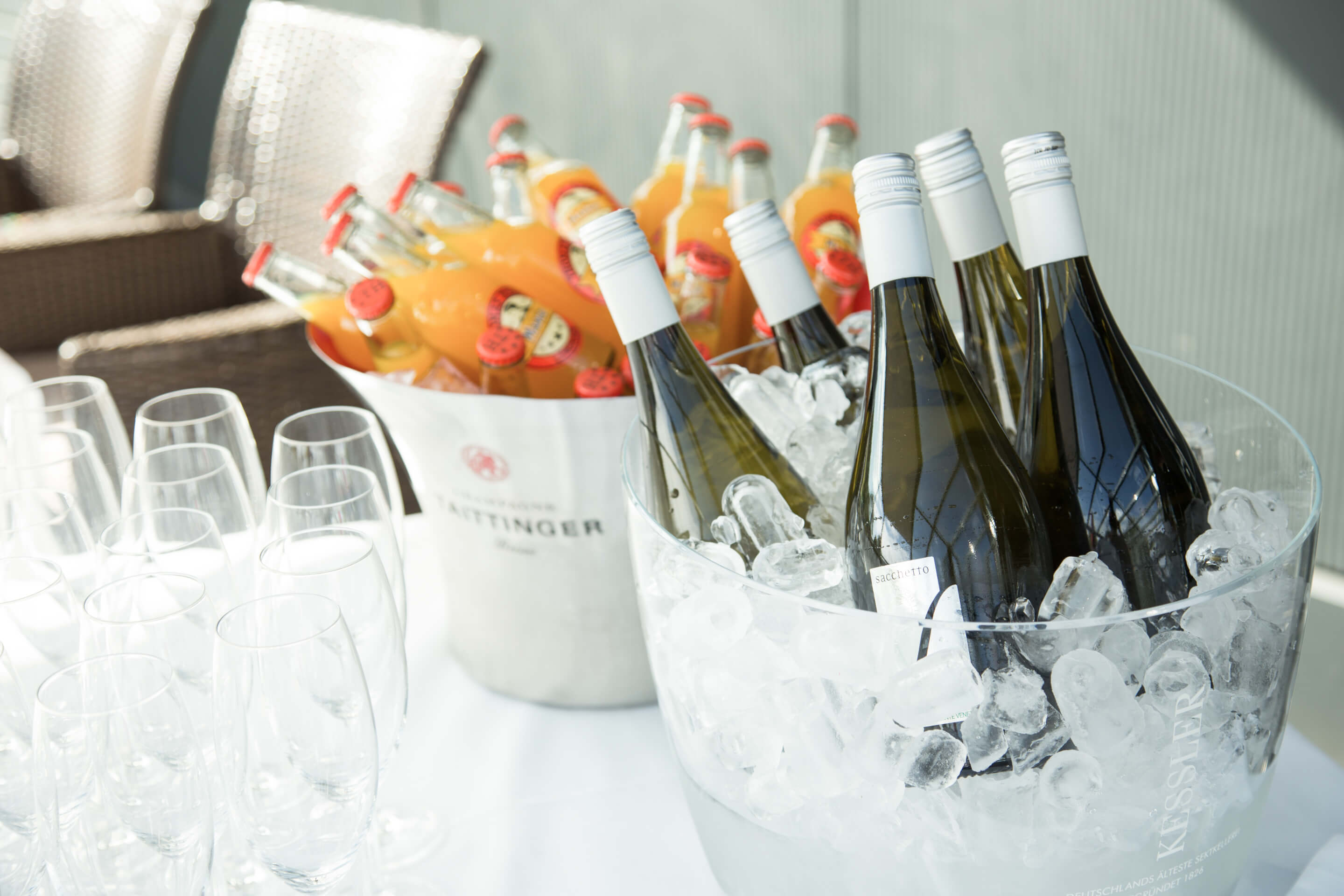 Aufnahme eines Sektkühlers und Säften, mit Gläsern auf einem weiß gedeckten Tisch