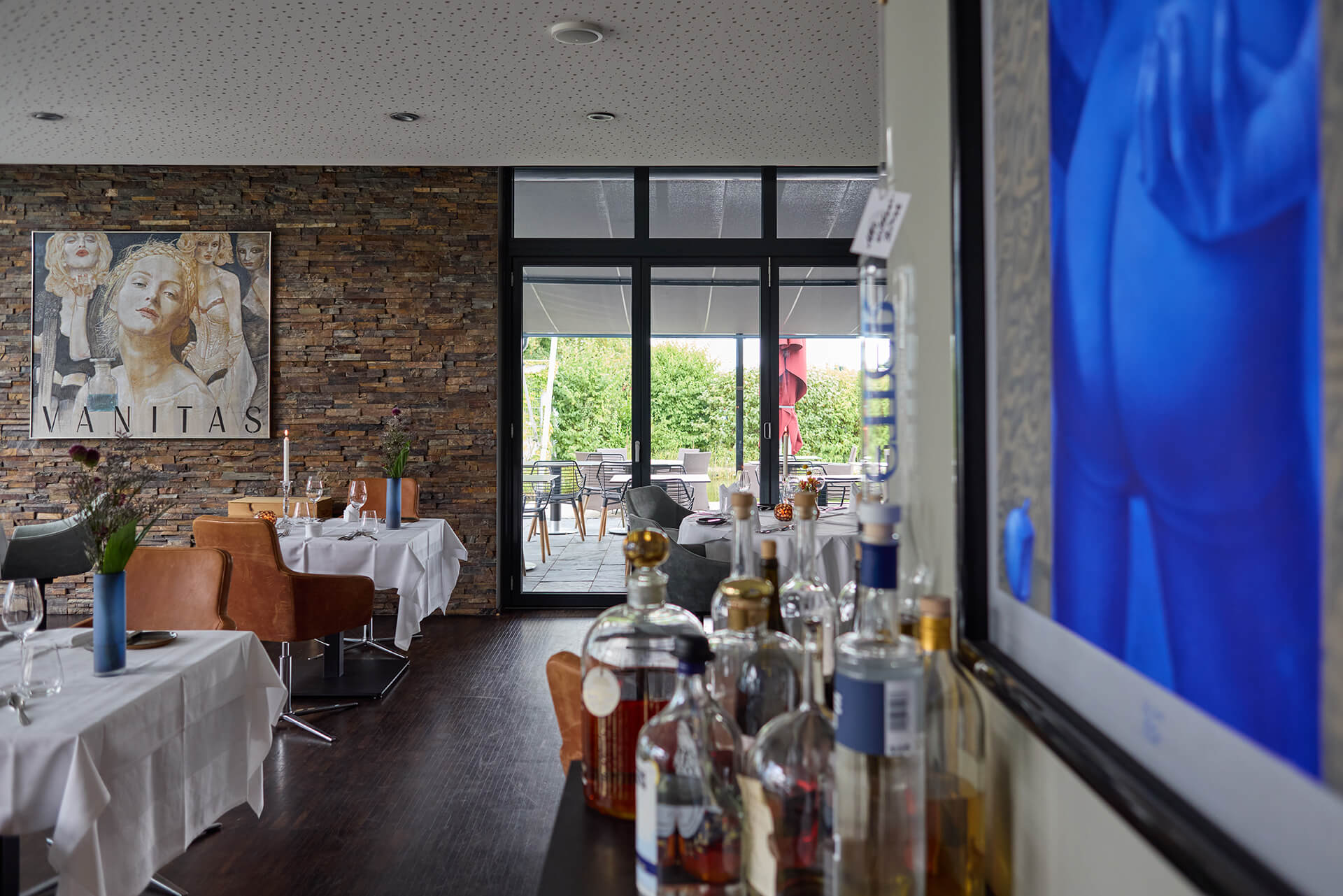 Blick von drinnen am Gemäde vorbei nach draußen auf die Terrasse