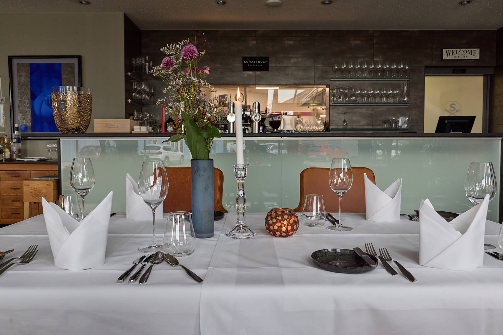 Foto des Innenbereichs im Restaurant mit Blick auf die Theke und das Sichtfenster in die Küche hinein