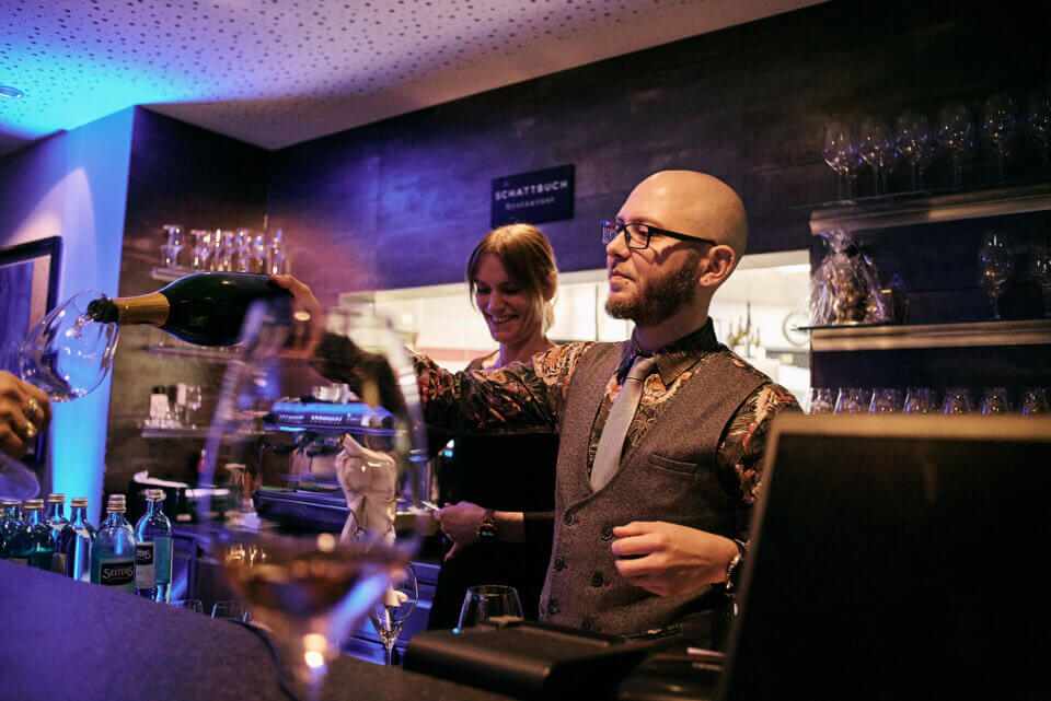 Foto von der Bar, an der gerade ein Weinglas nachgeschenkt wird