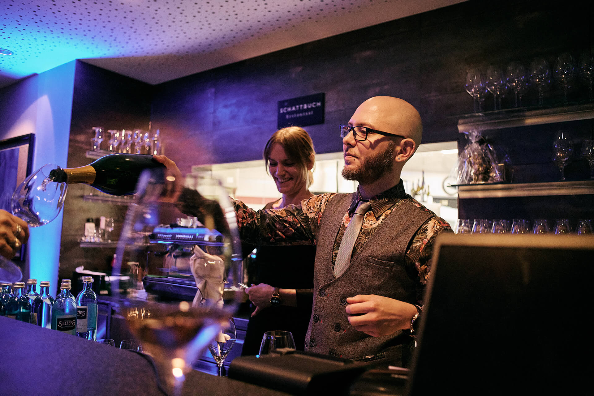 Foto von der Bar, an der gerade ein Weinglas nachgeschenkt wird