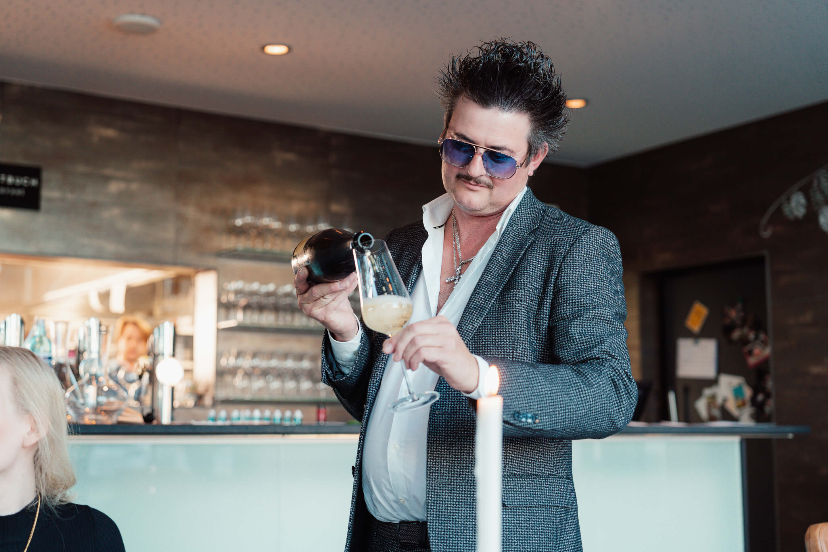 Aufnahme von Restaurantleiter Christian Marz, der einen Sekt als Aperitif ins Glas einschenkt.
