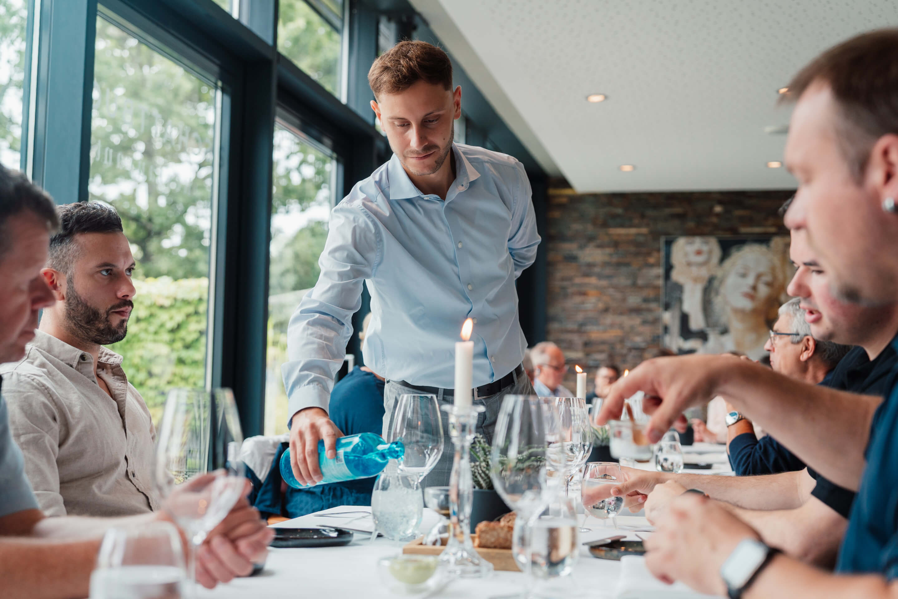 Kellner am Mittagstisch, bedient eine Gruppe während eines Geschäftsessens