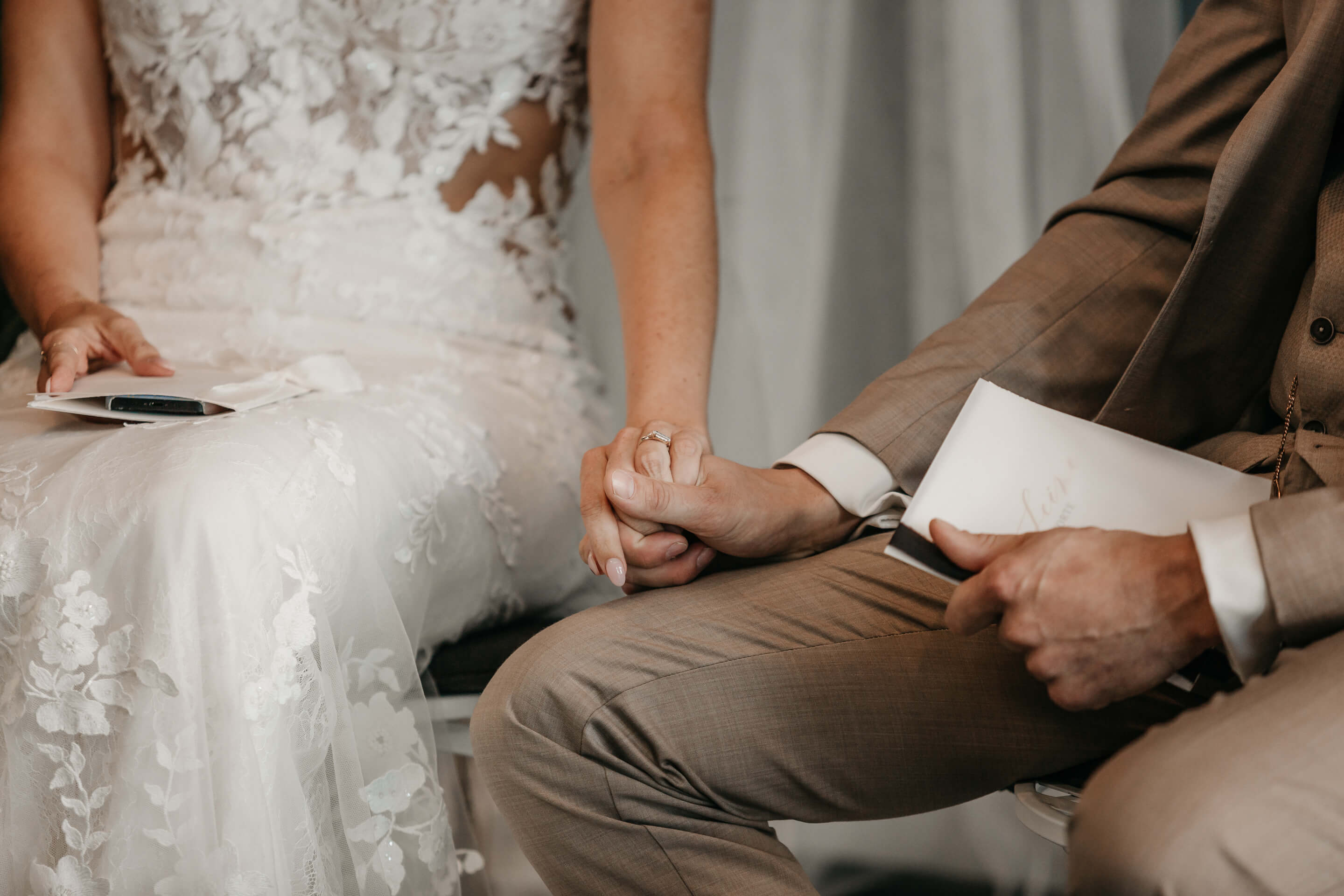 Bräutigam und Braut Hand in Hand während der Trauung